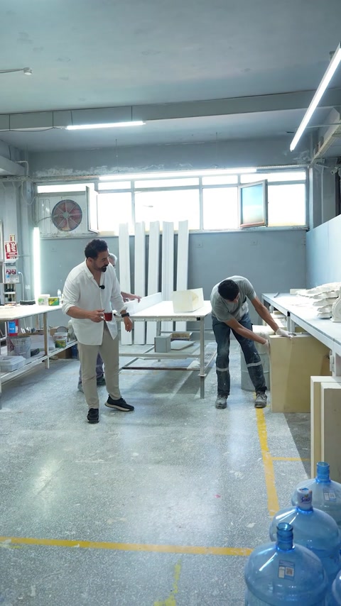 Workers prepare a large panel inside the polyurethane production workshop