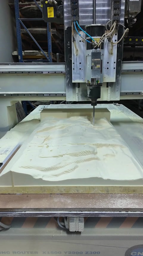 Routing head shapes the sculptural surface across the large panel