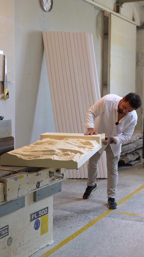 Worker smooths and prepares a large relief panel for finishing