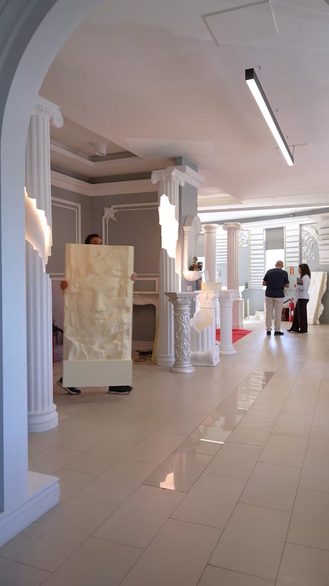 Showroom displays decorative columns and a large sculptural relief panel