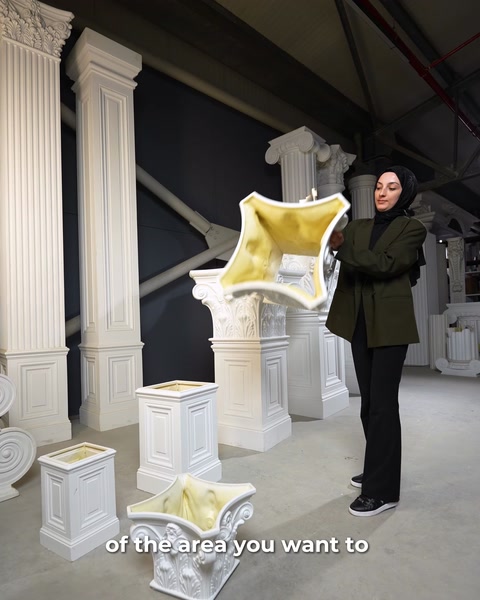 Donna che tiene un telo protettivo giallo accanto alla base del capitello