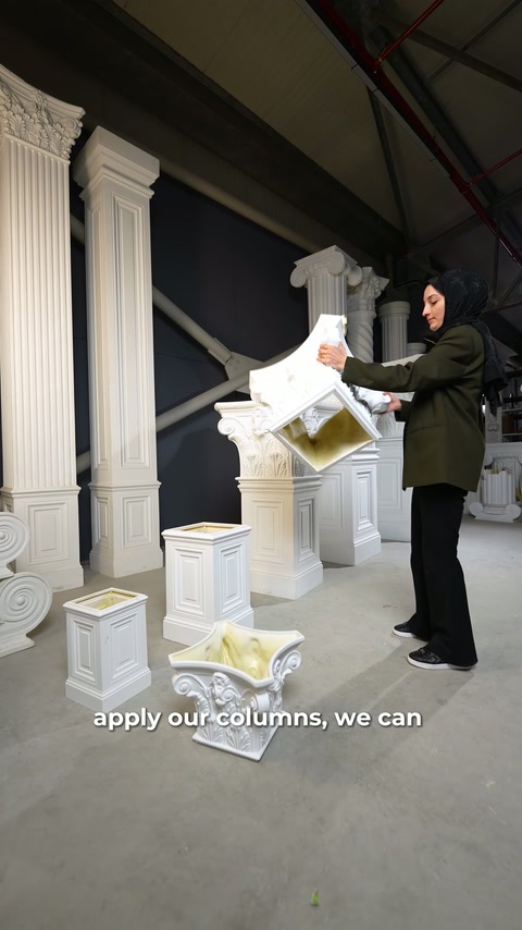 Consultant examines a decorative component beside full-size showroom capitals