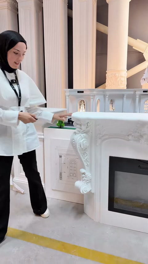 Kabartmalı şömine çerçevesi showroom sütunları arasında öne çıkıyor