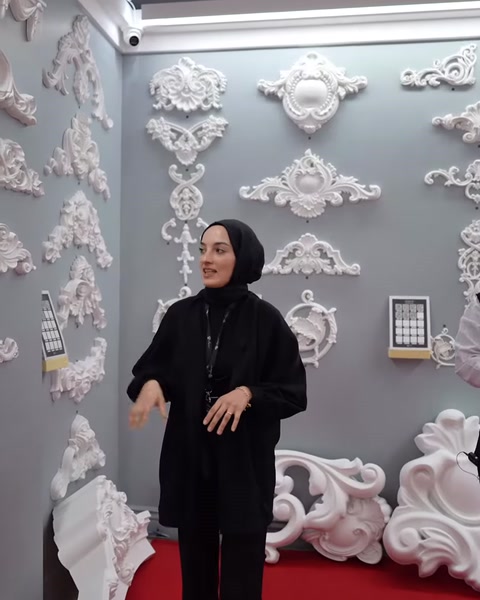 Il presentatore illustra diversi piccoli modelli di cornice installati sulla parete.