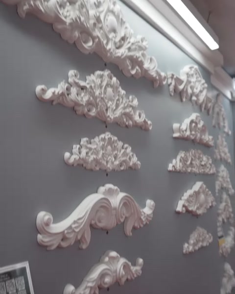 Vengono mostrati da vicino i modelli di cornice lunghi e curvati sulla parete espositiva.