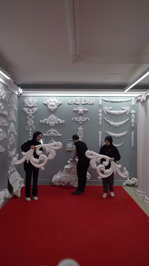 Tre persone espongono insieme grandi pezzi di piedistallo di cornice curva