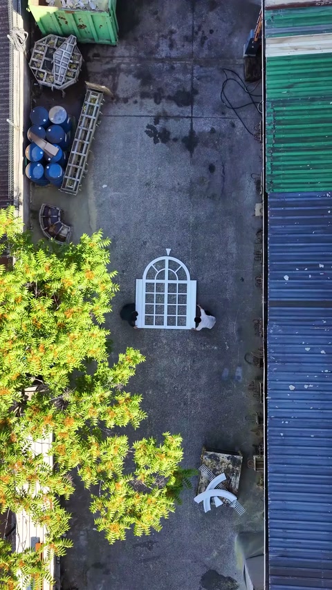 Workers carrying decorative surround pieces to window frame area