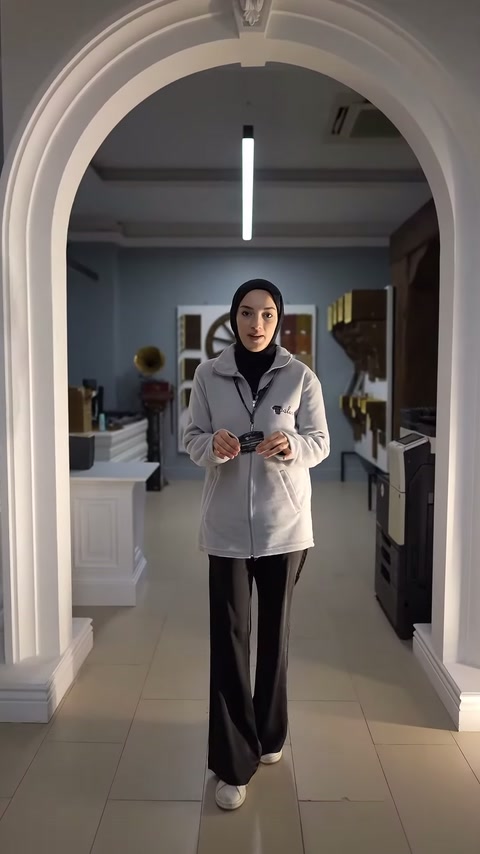 Sunucu, kemerli showroom geçidinde dekoratif ürünler hakkında bilgi veriyor