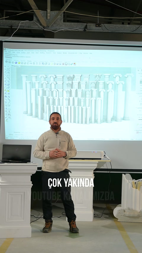 Sunucu, showroomdaki projeksiyon önünde sütun çeşitlerini anlatıyor.