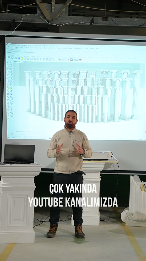 Showroomda sunucu, ekrandaki farklı sütun modellerinin önünde konuşuyor.