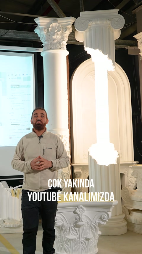 Sunucu, yüksek beyaz sütunlar ve kemerli paneller arasında duruyor.