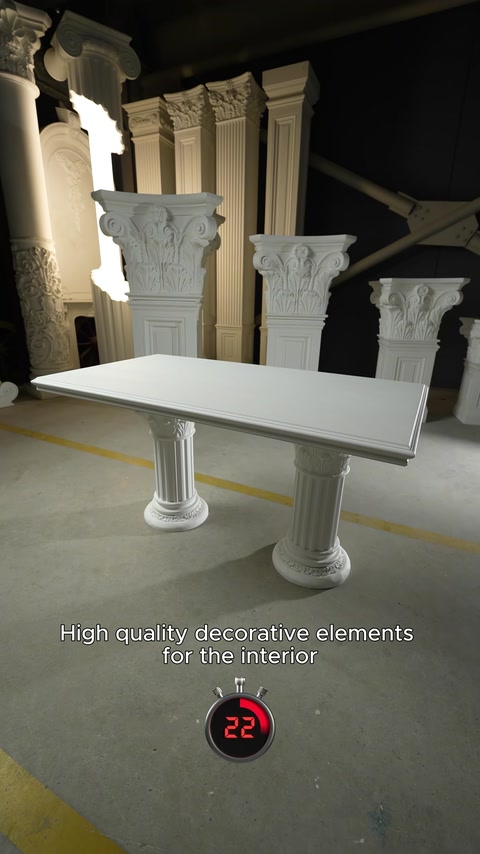 Capitelli di colonne e un tavolo con piedistallo sono esposti sul pavimento dello showroom