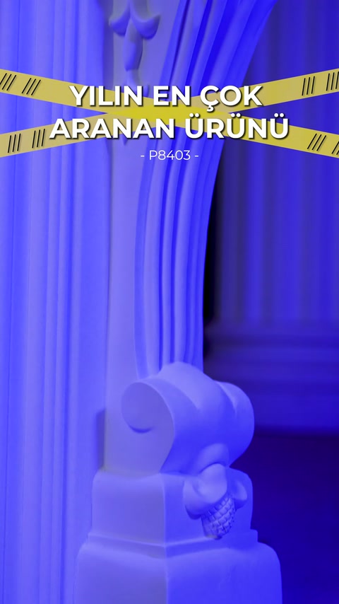 Blue light accentuates fluting and volute-shaped ornament on fireplace edge.