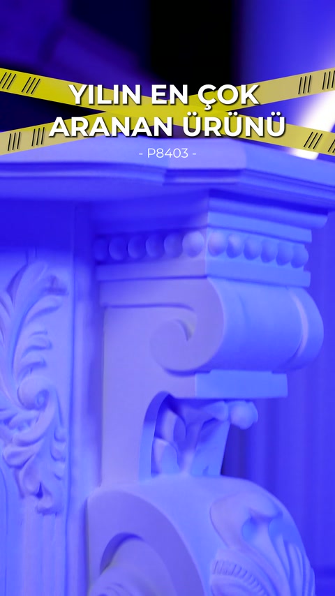 Blue illumination emphasizes layered moldings and embossments at fireplace corner.