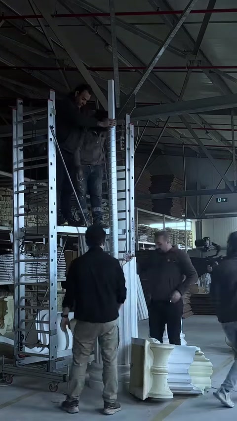 Gli artigiani lavorano uno di fronte all’altro nel punto di giunzione del fusto della colonna.