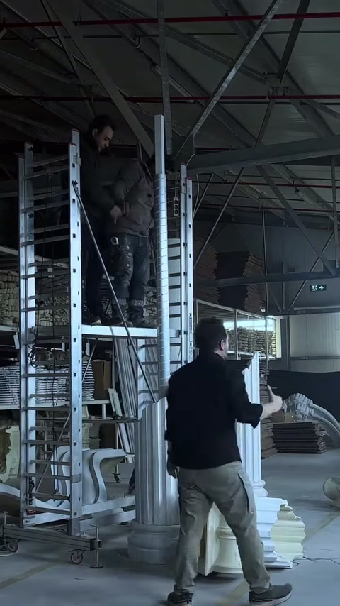 Il lungo componente bianco della colonna viene avvicinato al fusto sulla base.