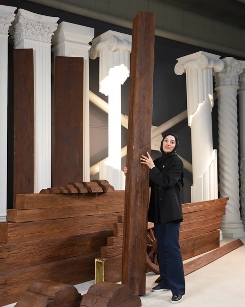 Una donna tiene una trave verticale in poliuretano appoggiata a colonne classiche