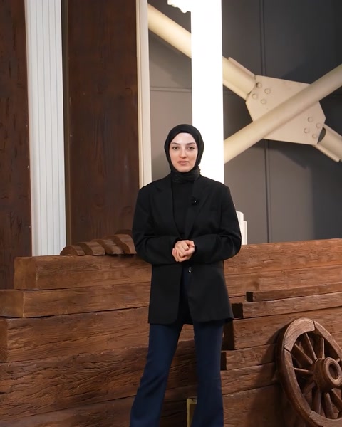 La presentatrice è in piedi con calma parlando della collezione di prodotti architettonici in poliuretano