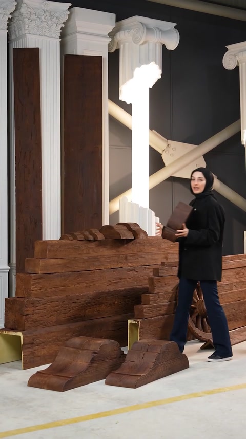 Presenter stands beside polyurethane beam column near classical pillars