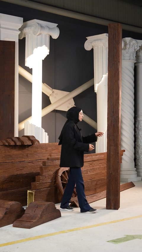 Presenter walks toward stacked polyurethane beam column indoors