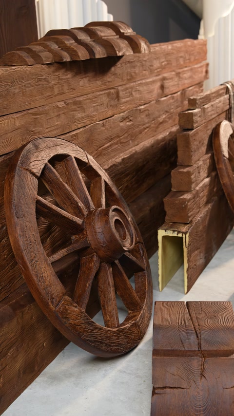 Decorative wheel positioned beside U-shaped cross-section wood-look beams