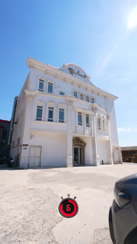 Completed white facade showcases window surrounds, cornices, and ornamental cresting.