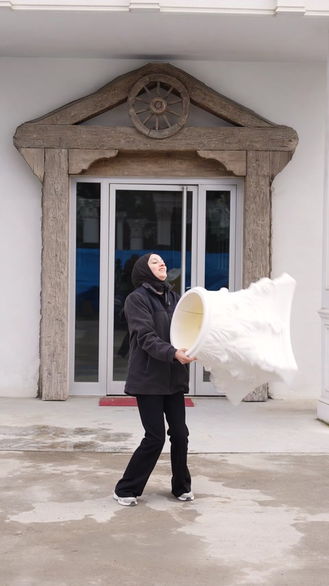 A presenter displays an ornate polyurethane capital beside a decorated entrance.