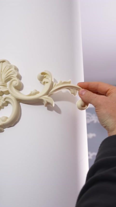 A curved appliqué detail is brought close to a round column surface