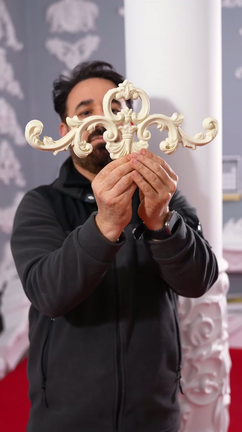 A carved-look flexible appliqué is presented from the front with both hands indoors.