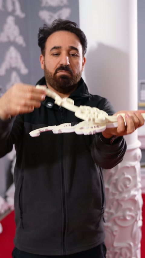A craftsman bends the appliqué wing to demonstrate the component's movable form.