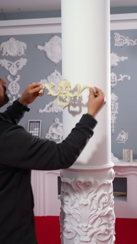 A flexible ornament is aligned on the surface before being applied to the round column.